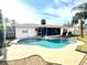 Relaxing kidney-shaped pool with a screened lanai, surrounded by lush landscaping at 2172 University S Dr, Clearwater, FL 33764