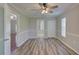 Bedroom with wood-look floors, closet, and fan, leading into an ensuite bathroom, brightened by natural light at 2333 Appaloosa Cir, Sarasota, FL 34240