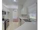 Bright kitchen with white cabinetry, tile floor, stainless appliances, and a view into the dining area at 2333 Appaloosa Cir, Sarasota, FL 34240