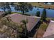 A sunny aerial view showcasing the home's roof and its proximity to a pond at 2609 Locksley St, Sun City Center, FL 33573