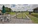 Outdoor bocce ball court surrounded by manicured landscaping, with table seating in the foreground at 2609 Locksley St, Sun City Center, FL 33573