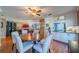 Open-concept dining area that flows into a spacious living room and modern kitchen with white cabinets at 2609 Locksley St, Sun City Center, FL 33573