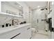 Elegant bathroom featuring a double sink vanity, illuminated mirror, and a glass-enclosed shower at 3934 Doral Dr, Tampa, FL 33634