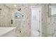 Luxurious bathroom featuring marble walls, a glass shower, and an open doorway to a toilet room at 3934 Doral Dr, Tampa, FL 33634