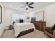 Bright bedroom features a ceiling fan, large window, and wooden dresser with a TV on top at 3934 Doral Dr, Tampa, FL 33634