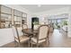 Dining room with a round wooden table and view to the open concept living space and backyard at 3934 Doral Dr, Tampa, FL 33634