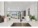 Modern kitchen featuring a stainless steel sink, white cabinets, and a view to the living room at 3934 Doral Dr, Tampa, FL 33634