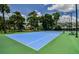 Community tennis courts with blue surface, green perimeter, benches, and lights at 3934 Doral Dr, Tampa, FL 33634