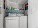 Convenient laundry room with modern washer and dryer, and storage shelf at 440 Sandy Hook Rd, Treasure Island, FL 33706