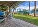 Covered brick patio with chairs, lush grass, and views of the tennis courts at 440 Sandy Hook Rd, Treasure Island, FL 33706