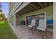 Relaxing outdoor patio featuring brick pavers, two lounge chairs, a grill, and a spiral staircase at 440 Sandy Hook Rd, Treasure Island, FL 33706