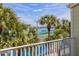 Scenic view from the balcony showcasing palm trees, tennis courts, and a waterfront backdrop at 440 Sandy Hook Rd, Treasure Island, FL 33706