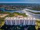 Aerial view of a waterfront condominium building featuring balconies and water views at 4516 Seagull Dr # 405, New Port Richey, FL 34652