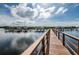 Scenic water view featuring a long wooden boat dock with multiple boat slips under a partly cloudy sky at 4516 Seagull Dr # 405, New Port Richey, FL 34652