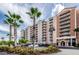 Condominium building exterior featuring multiple stories with lots of balconies, landscaping, and a parking lot at 4516 Seagull Dr # 405, New Port Richey, FL 34652