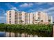 Exterior shot of a luxurious multi-story condominium complex with private balconies and lush landscaping at 4516 Seagull Dr # 405, New Port Richey, FL 34652