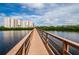 Scenic view of a long wooden bridge leading to a multi-story condominium complex with a beautiful waterfront at 4516 Seagull Dr # 405, New Port Richey, FL 34652