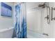 Bathroom featuring a tub/shower with blue shower curtain, modern fixtures, and tiled accents at 4525 Cove Cir # 805, St Petersburg, FL 33708