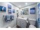 Well-lit bathroom with blue accents, featuring a modern vanity, mirror, and coordinated decor at 4525 Cove Cir # 805, St Petersburg, FL 33708