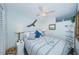 Bright bedroom with a ceiling fan, coastal accents, and a cozy bed with blue and white linens at 4525 Cove Cir # 805, St Petersburg, FL 33708