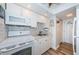 Well-lit kitchen with white cabinets, stainless steel sink, and a decorative backsplash at 4525 Cove Cir # 805, St Petersburg, FL 33708