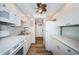 Galley kitchen featuring white cabinetry, modern appliances, and wood-look flooring at 4525 Cove Cir # 805, St Petersburg, FL 33708