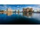 Waterfront view of condominium buildings reflecting in water under a sunny, partly cloudy sky at 4525 Cove Cir # 805, St Petersburg, FL 33708