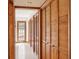 Hallway with multiple wooden shutter door closets offering plentiful storage and a view of the front door to the outside at 4801 Umber Ct, Tampa, FL 33624