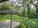 Serene backyard with a covered patio, lush green lawn, and mature trees providing ample shade at 4802 W San Jose St, Tampa, FL 33629