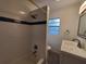 Bathroom with shower-tub combination featuring white subway tile and blue accent stripe at 4802 W San Jose St, Tampa, FL 33629