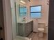 Updated bathroom features a glass enclosed shower, gray vanity, and tiled floors at 4802 W San Jose St, Tampa, FL 33629