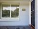 Close-up of the front door, showcasing the house number, decorative tile, and a window with white shutters at 4802 W San Jose St, Tampa, FL 33629