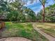 Lush backyard with a brick path, mature trees, and manicured greenery, offering a tranquil and private outdoor space at 5001 S Shore Crest Cir, Tampa, FL 33609