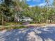 A beautiful brick driveway leads up to a stately white home surrounded by lush greenery and mature trees at 5001 S Shore Crest Cir, Tampa, FL 33609