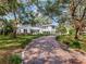 Elegant white home with a long brick driveway lined with greenery, providing a picturesque entrance at 5001 S Shore Crest Cir, Tampa, FL 33609