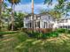 Elegant two-story white home featuring black shutters and lush landscaping at 5001 S Shore Crest Cir, Tampa, FL 33609