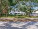 Charming two-story white home with black shutters, mature trees, and a well-manicured lawn at 5001 S Shore Crest Cir, Tampa, FL 33609