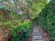 Charming garden path with lush greenery, flowering bushes, and a decorative gate leading to a serene outdoor space at 5001 S Shore Crest Cir, Tampa, FL 33609