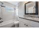 Bright bathroom featuring granite counters, updated fixtures, and a shower-tub combo at 5020 16Th N Ave, St Petersburg, FL 33710