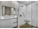 Well-lit bathroom with double vanity, large mirror, and frameless shower at 525 Lamara Ne Way, St Petersburg, FL 33704