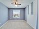 Bedroom featuring a window, carpet, blue walls with white accents, and a ceiling fan at 6929 Breezy Palm Dr, Riverview, FL 33578