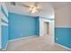 Cozy bedroom with blue accent wall, ceiling fan, and neutral carpet at 6929 Breezy Palm Dr, Riverview, FL 33578