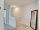 Upstairs hallway with white walls, carpet, and a mirror reflecting the natural light at 6929 Breezy Palm Dr, Riverview, FL 33578