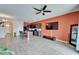 Open living area with modern decor, kitchen island seating, and a flat-screen TV on an orange accent wall at 6929 Breezy Palm Dr, Riverview, FL 33578