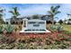 Community entrance sign 'Osprey Lakes West' surrounded by lush landscaping and colorful flowers at 6929 Breezy Palm Dr, Riverview, FL 33578