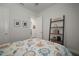 Neutral bedroom with patterned bed, ladder shelving unit with books and decor, and framed artwork at 7432 Paradiso Dr, Apollo Beach, FL 33572