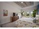 Light-filled bedroom with tray ceiling, flat screen television, and verdant outdoor views at 7432 Paradiso Dr, Apollo Beach, FL 33572