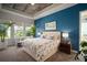 Bright bedroom features a floral comforter, tray ceiling, and a calming blue accent wall at 7432 Paradiso Dr, Apollo Beach, FL 33572