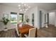 Bright dining area with views of the green backyard, wood table, and modern light fixture at 7432 Paradiso Dr, Apollo Beach, FL 33572