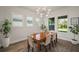 Elegant dining room featuring a stylish chandelier, wood floors, and an abundance of natural light at 7432 Paradiso Dr, Apollo Beach, FL 33572